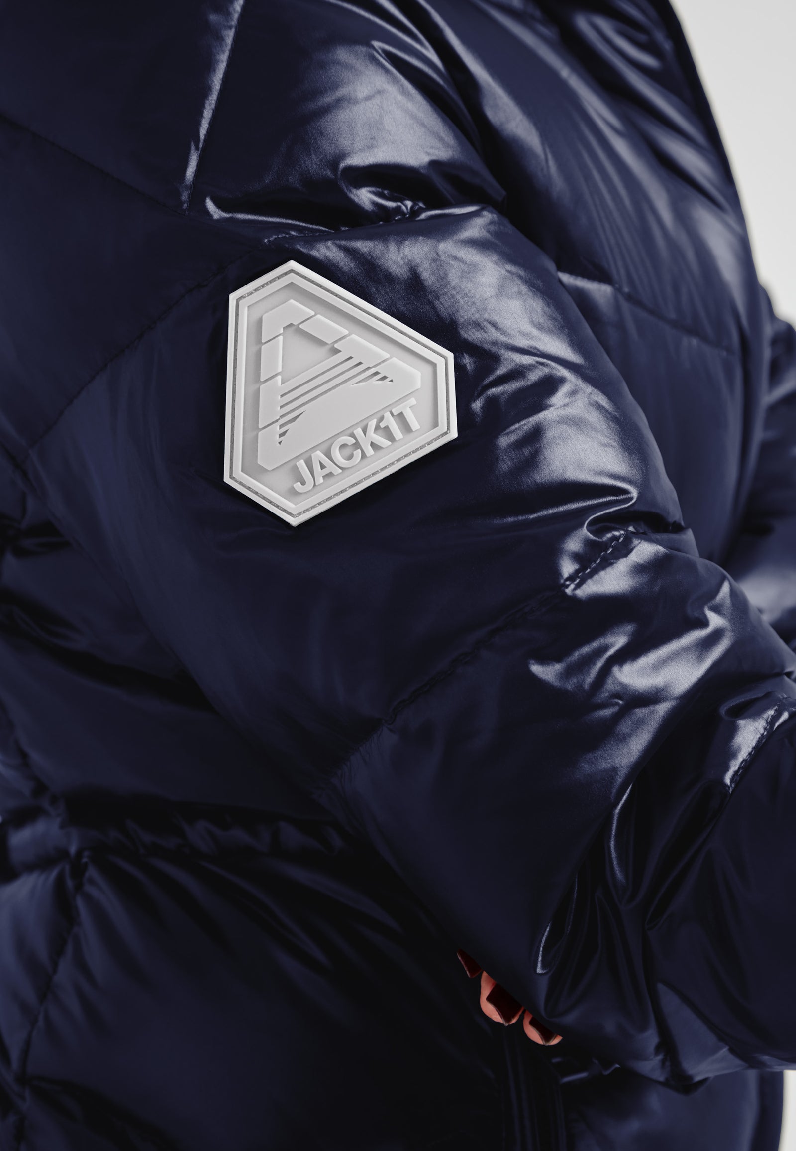 Womens navy down puffer coat featuring a logo patch on the sleeve for added style and branding.