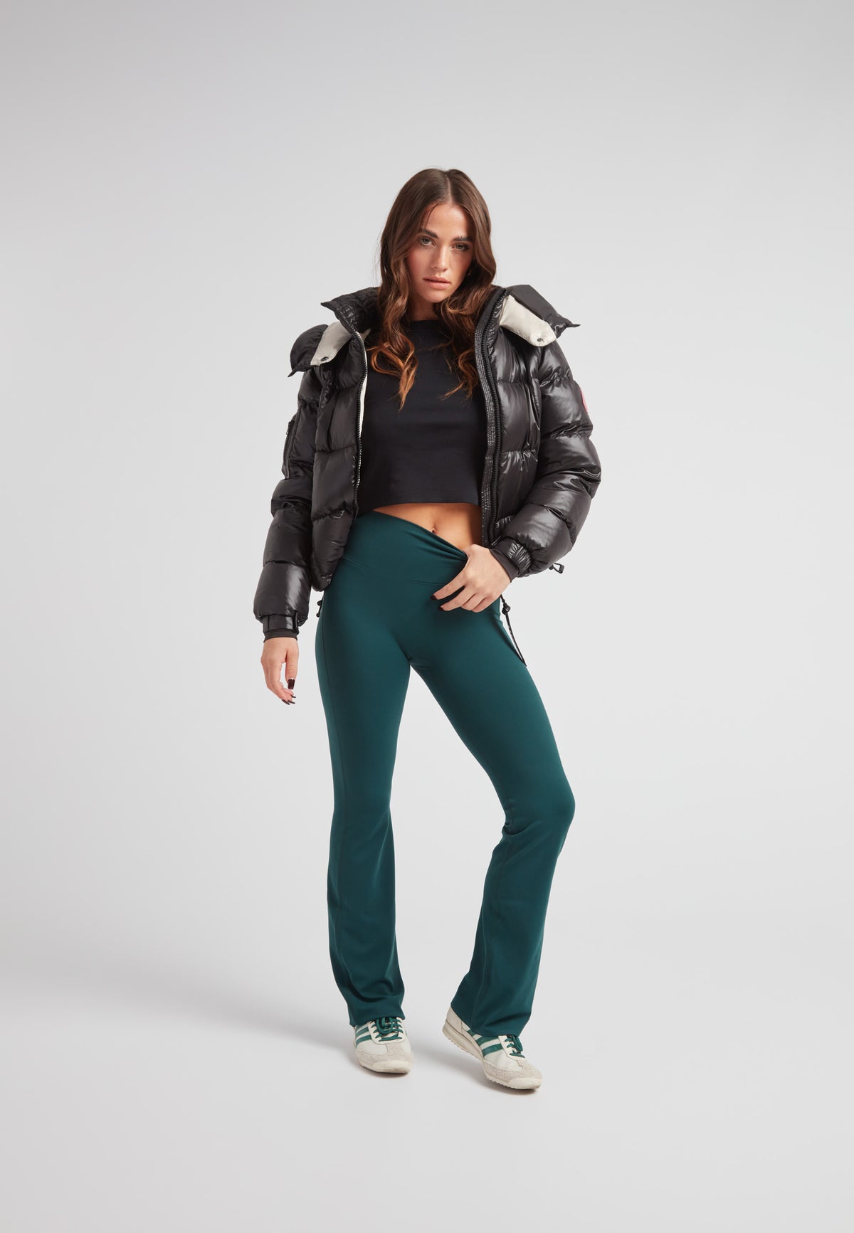 Model wearing EZ Boxed Crop Down Puffer Jacket Lux Black with green pants and sneakers.
