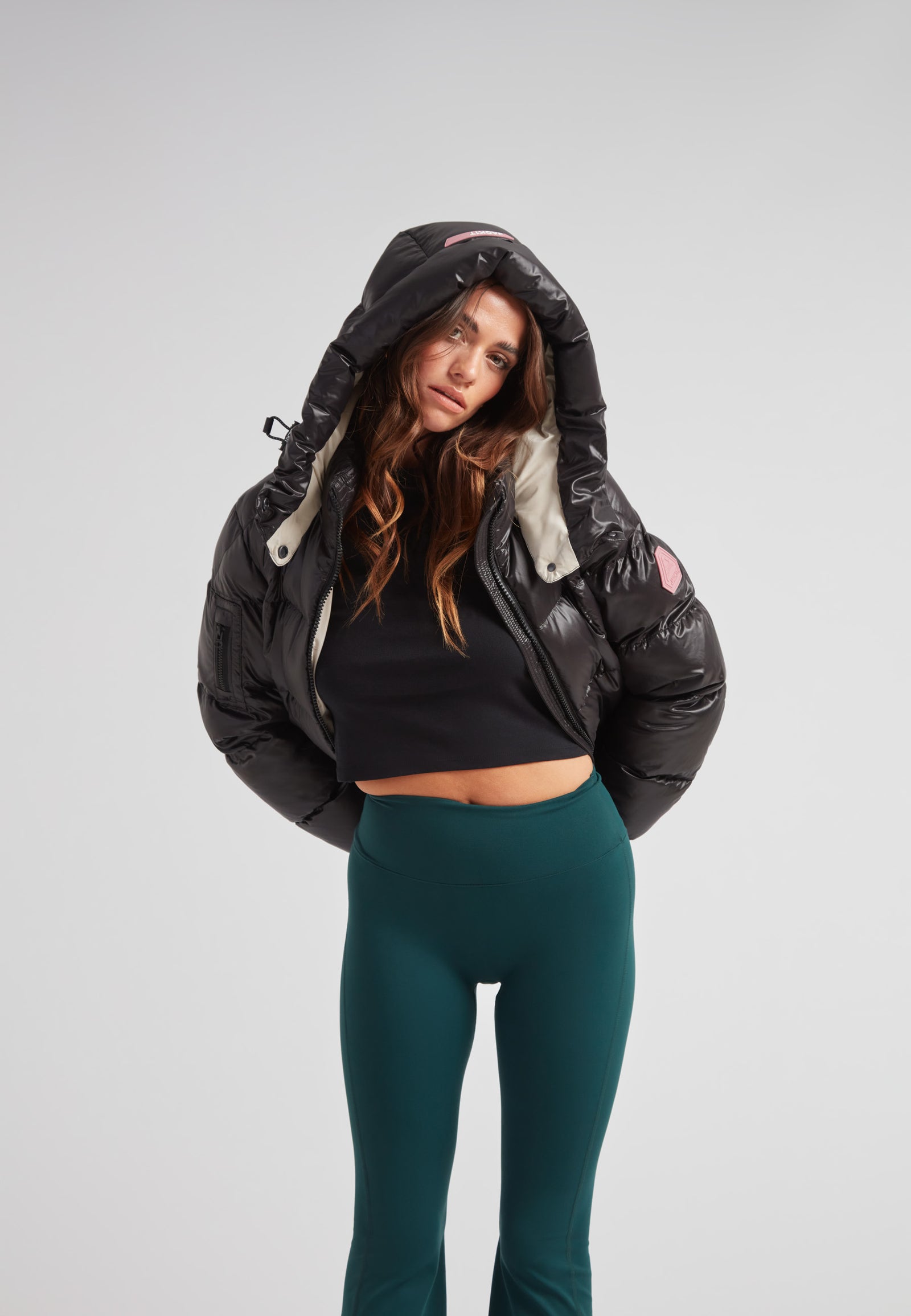 Model wearing EZ Boxed Crop Down Puffer Jacket Lux Black with hood, styled with fitted pants for a modern winter look.
