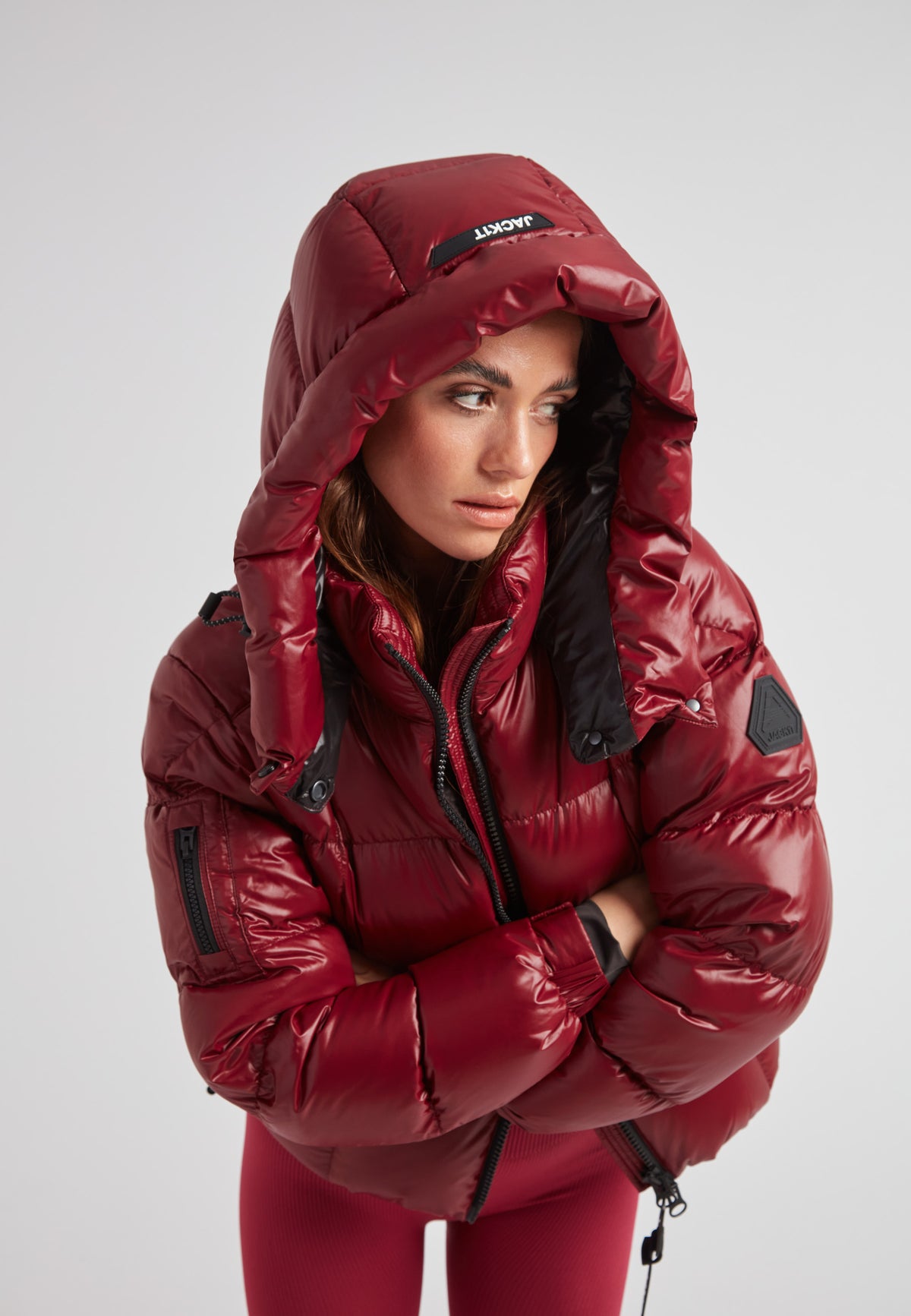 Model wearing EZ Boxed Crop Down Puffer Jacket Lux Cranberry with a hood in a striking pose.