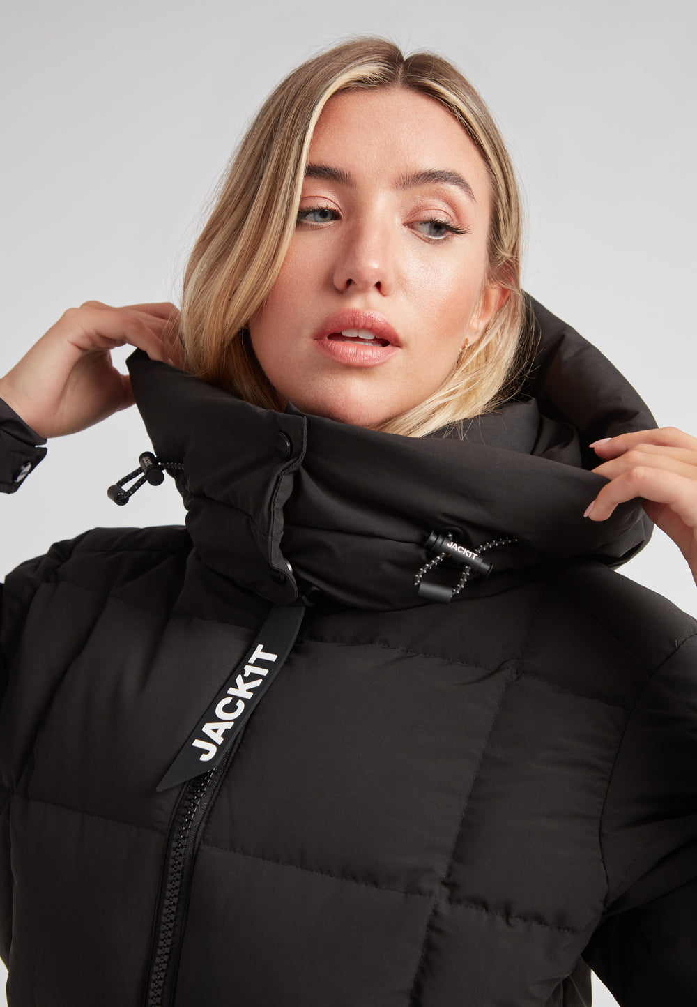 Woman wearing the EZ Boxed Racer Down Puffer Jacket Matt Black, showcasing the high collar and stylish details.