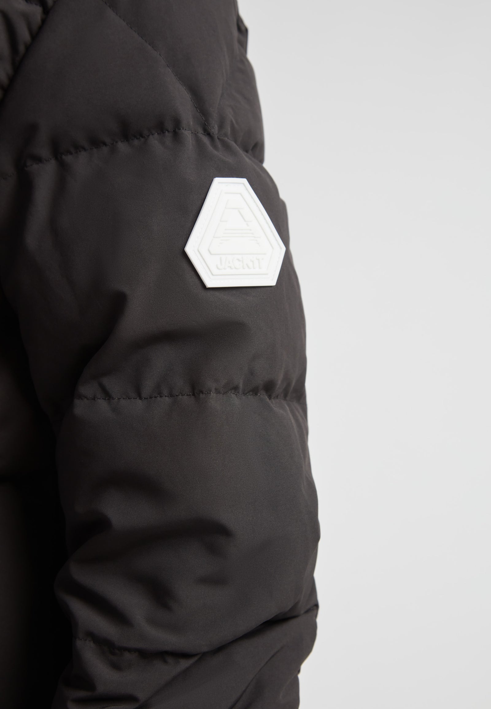 Close-up of the EZ Boxed Racer Down Puffer Jacket Matt Black showing the unique shoulder logo detail.