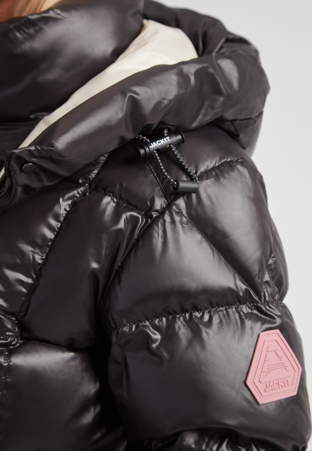 Close-up of the EZ Boxed Racer Down Puffer Jacket Lux Black showcasing its quilted texture and signature logo.