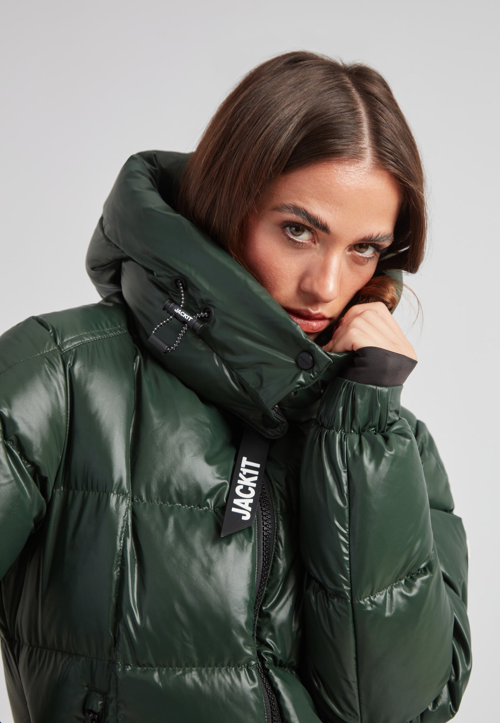 EZ Boxed Ultra Long Down Puffer Coat Lux Emerald on model, showcasing sleek emerald green fabric and high collar design.