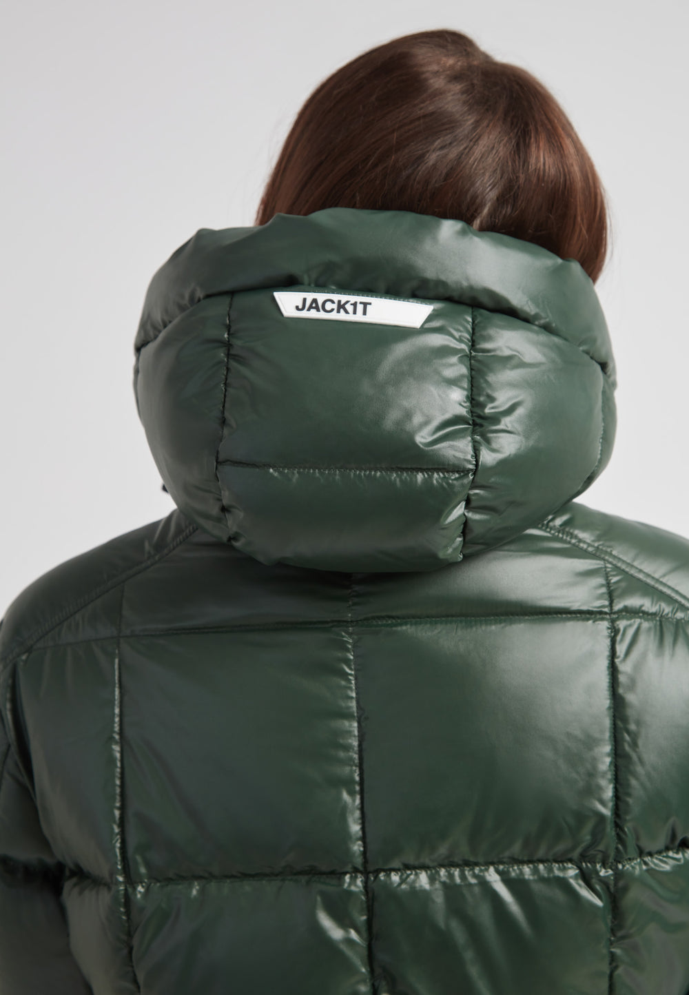 Back view of a woman wearing the EZ Boxed Ultra Long Down Puffer Coat Lux Emerald, showcasing its stylish hood and sleek design.