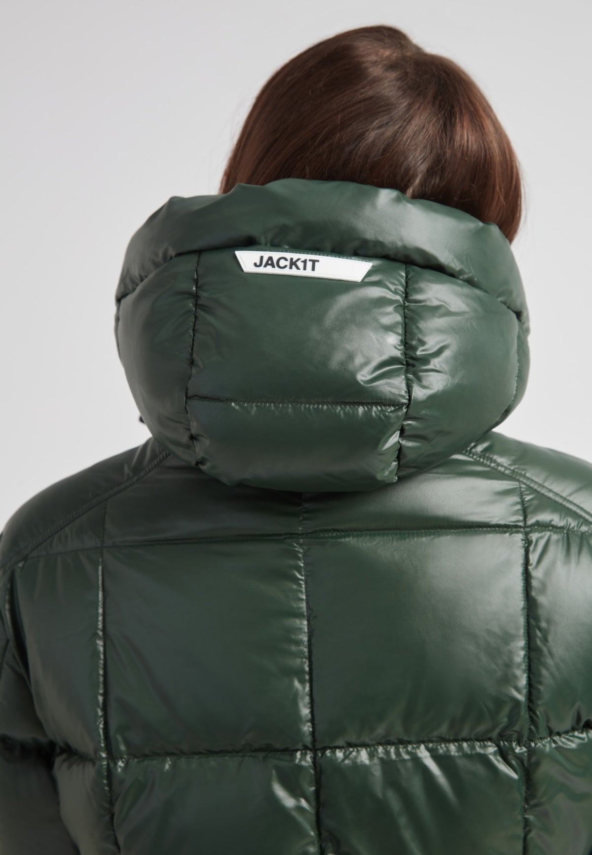Back view of a woman wearing the EZ Boxed Ultra Long Down Puffer Coat Lux Emerald, showcasing its stylish hood and sleek design.