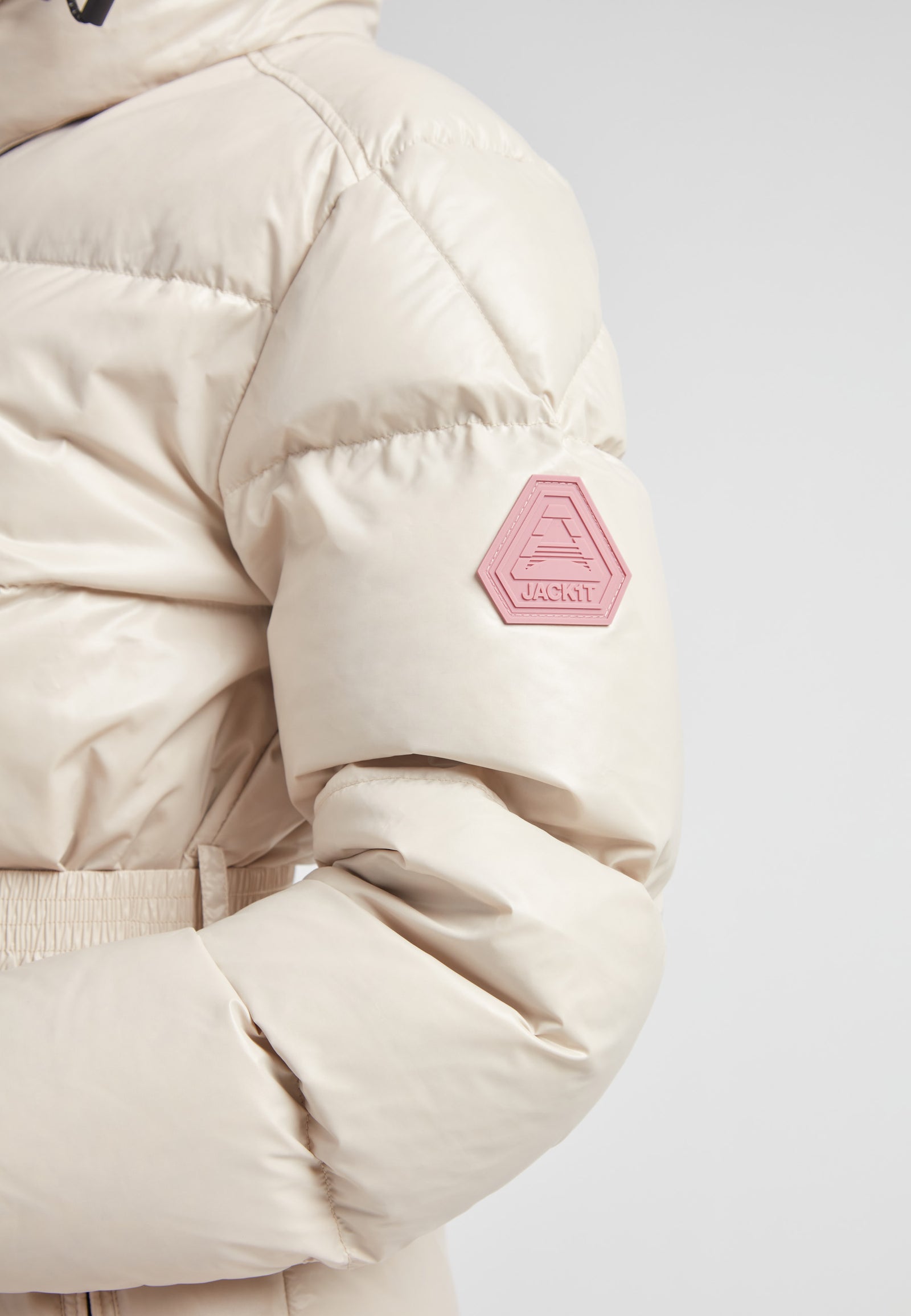 EZ Belted Down Puffer Coat Lux Stone featuring a smooth matte shell and stylish arm patch detail.