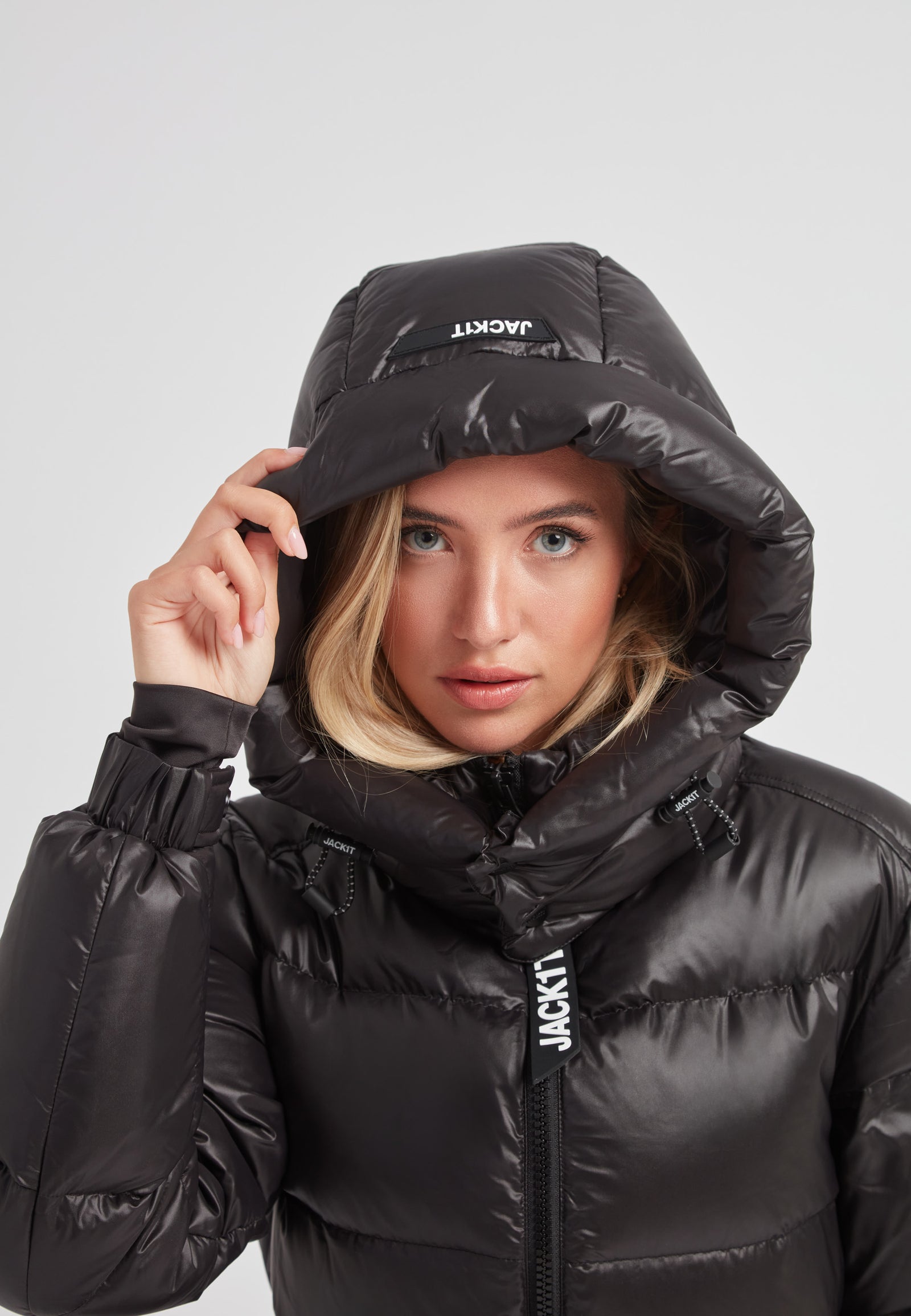 Woman in EZ Belted Down Puffer Coat Lux Black with hood, showcasing style and insulation.