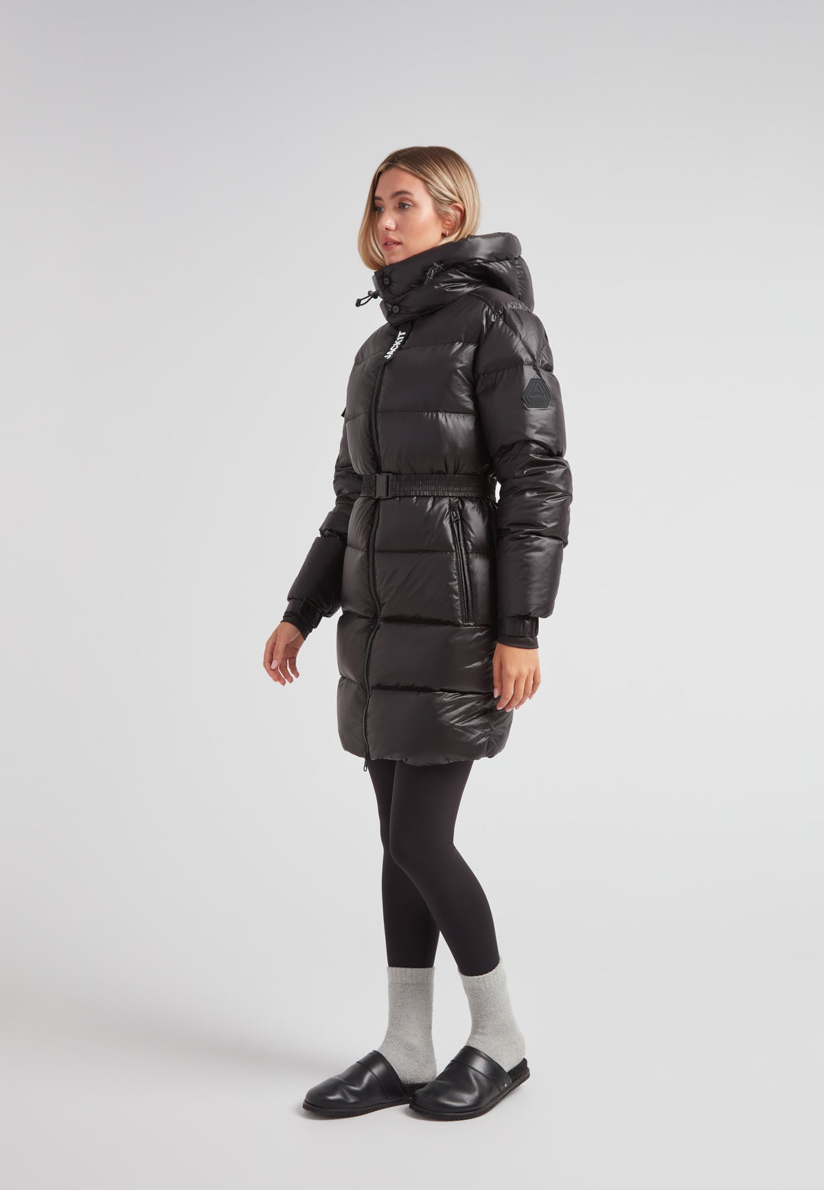Woman wearing the EZ Belted Down Puffer Coat Lux Black with a smooth matte finish and functional hood.