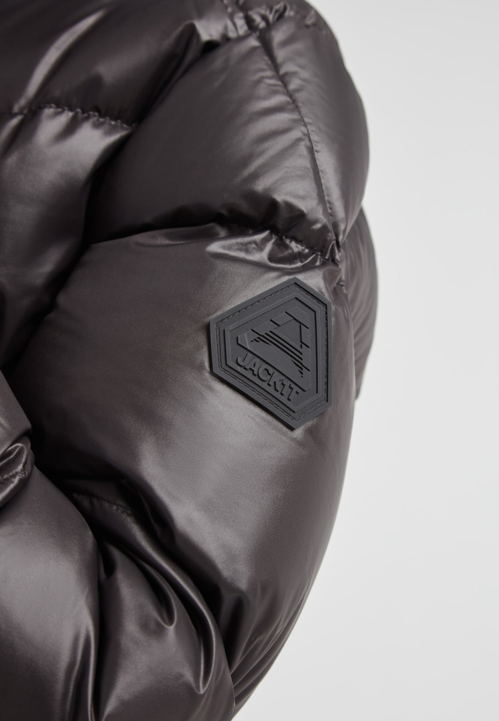Close-up of EZ Belted Down Puffer Coat Lux Black showing the durable fabric and logo detail.