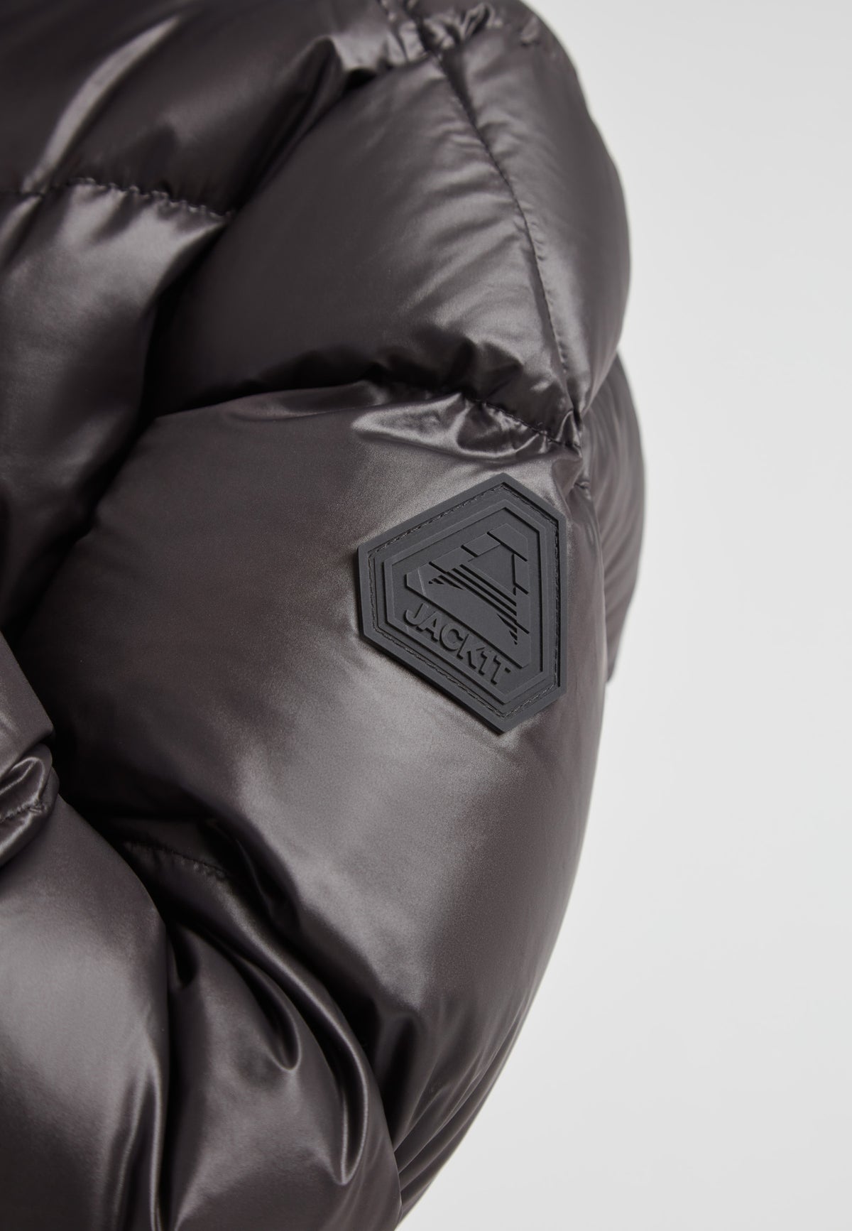 Close-up of EZ Belted Down Puffer Coat Lux Black showing the durable fabric and logo detail.