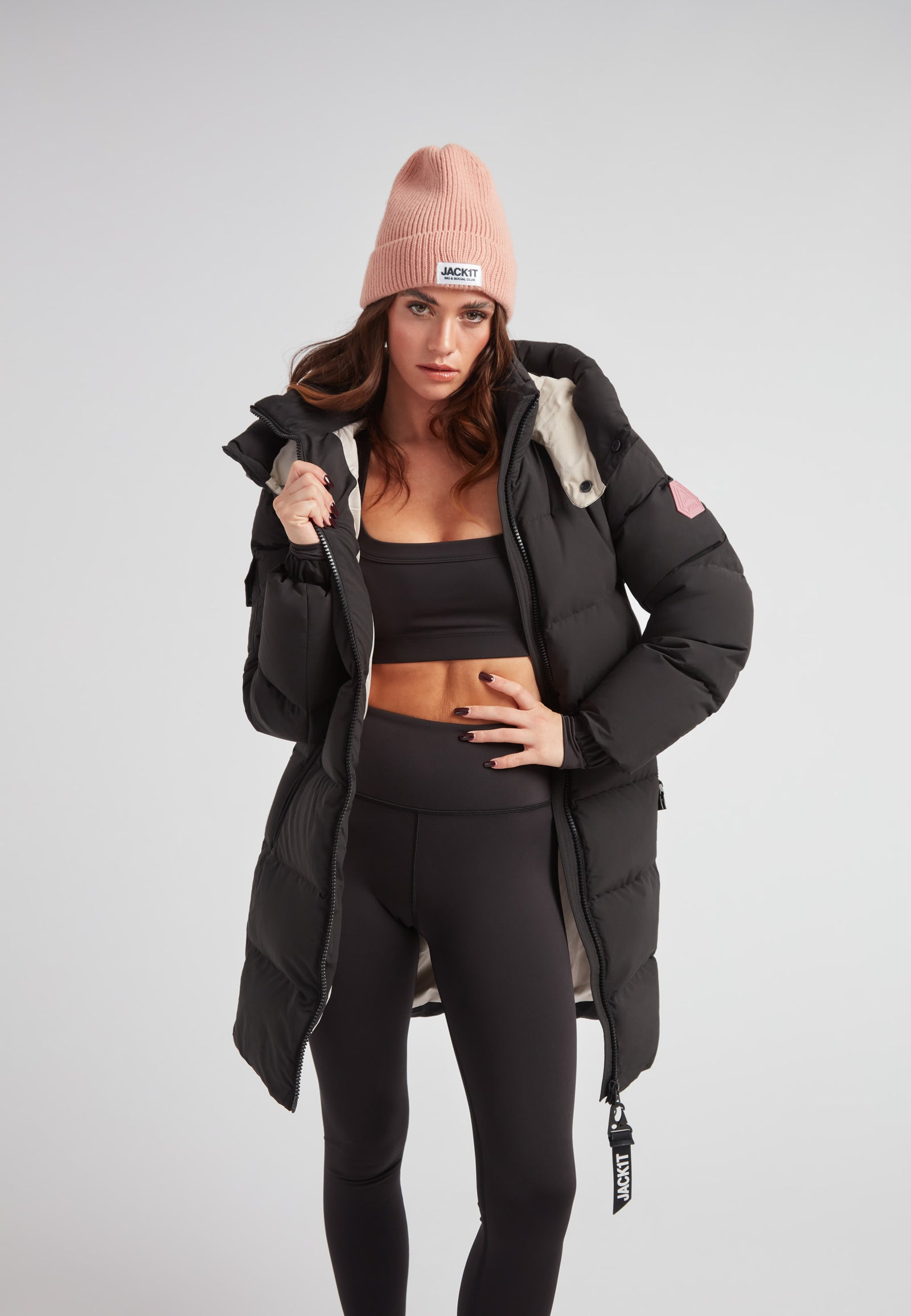 Model wearing the EZ Belted Down Puffer Coat Matt Black with a pink beanie, showcasing winter style and warmth.