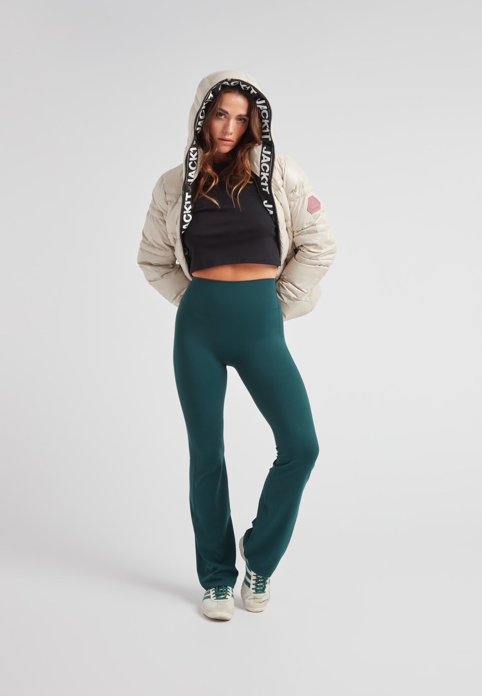 Model wearing R4D Tramline Puffer Racer Jacket Lux Stone with green pants and sneakers.