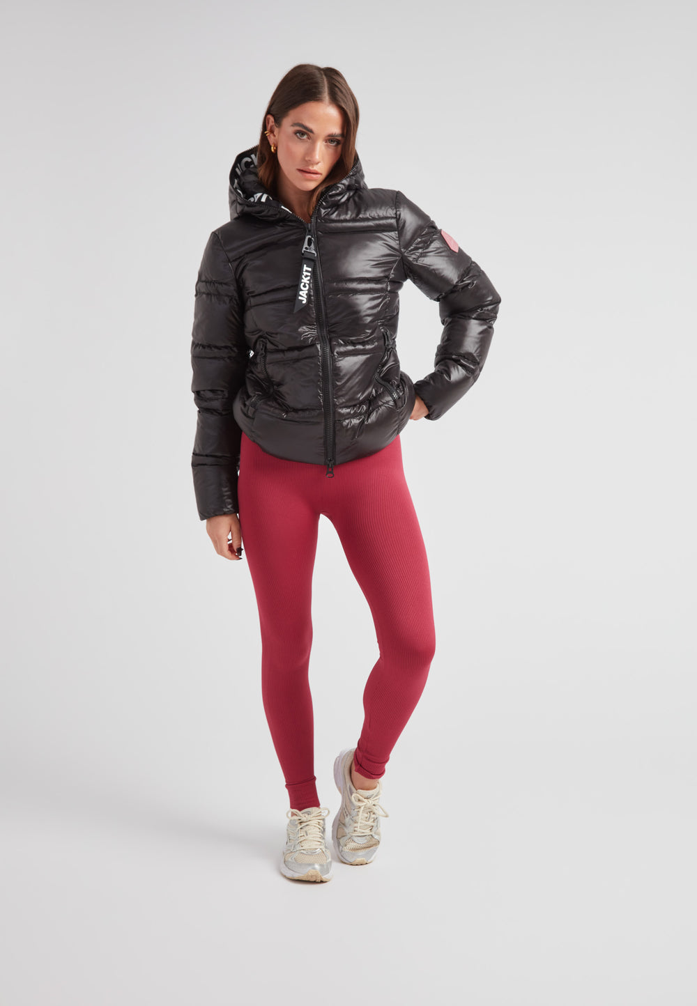 Woman wearing R4D Tramline Puffer Racer Jacket Lux Black with red leggings and sneakers.