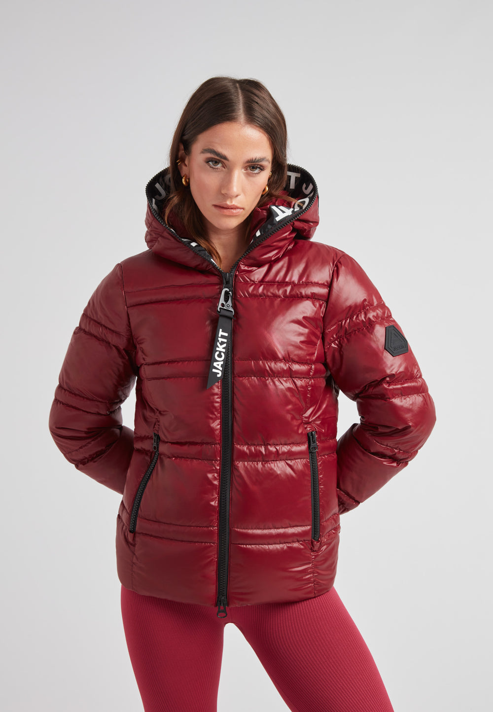 Model wearing the R4D Tramline Puffer Racer Jacket Lux Cranberry with a fixed hood and stylish design.