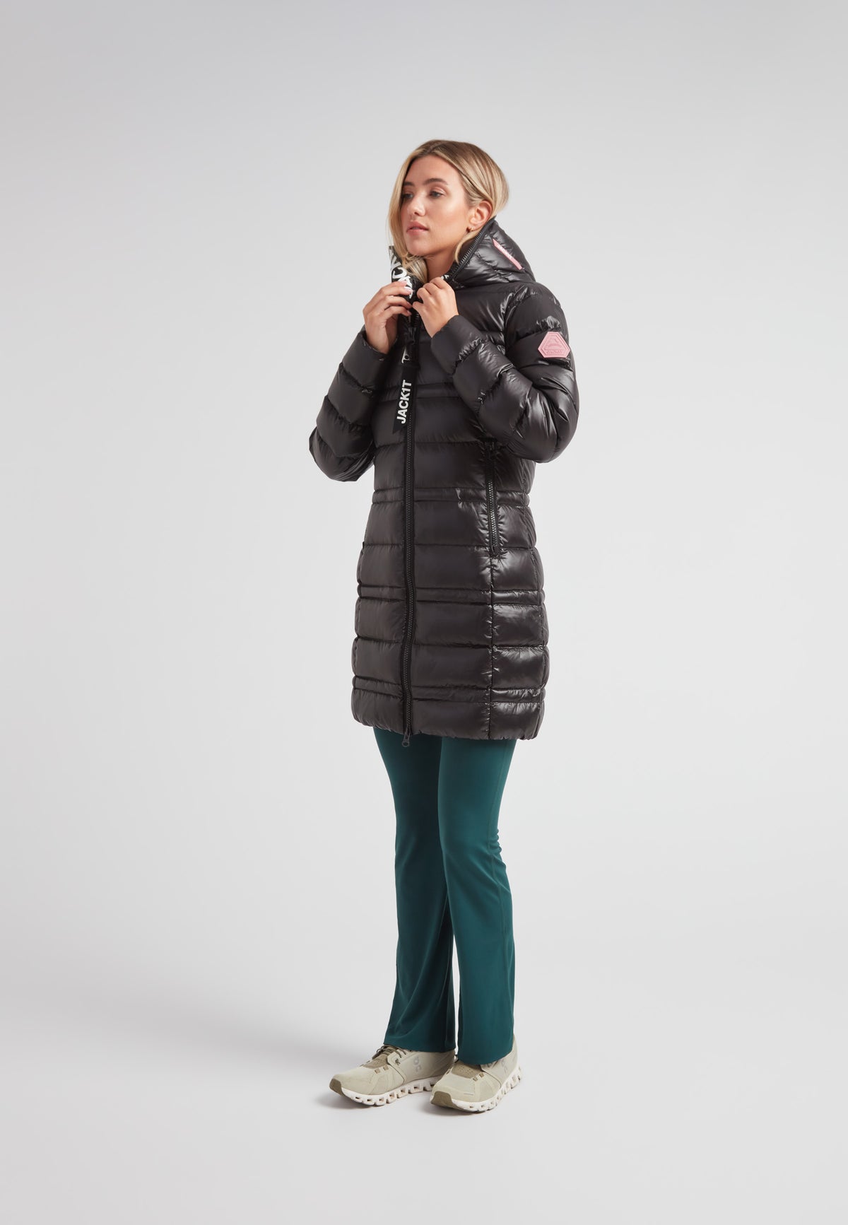 Woman wearing the R4D Tramline Down Coat Lux Black, stylish and warm, ideal for cold weather.