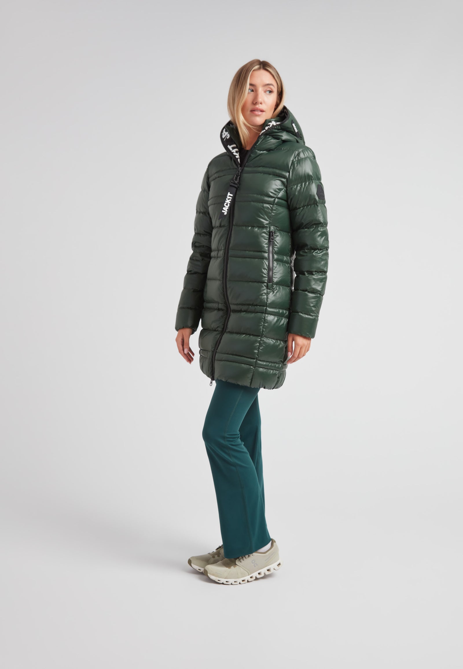 R4D Tramline Down Coat Lux Emerald on model, featuring a longline silhouette and a glossy water-repellent shell.