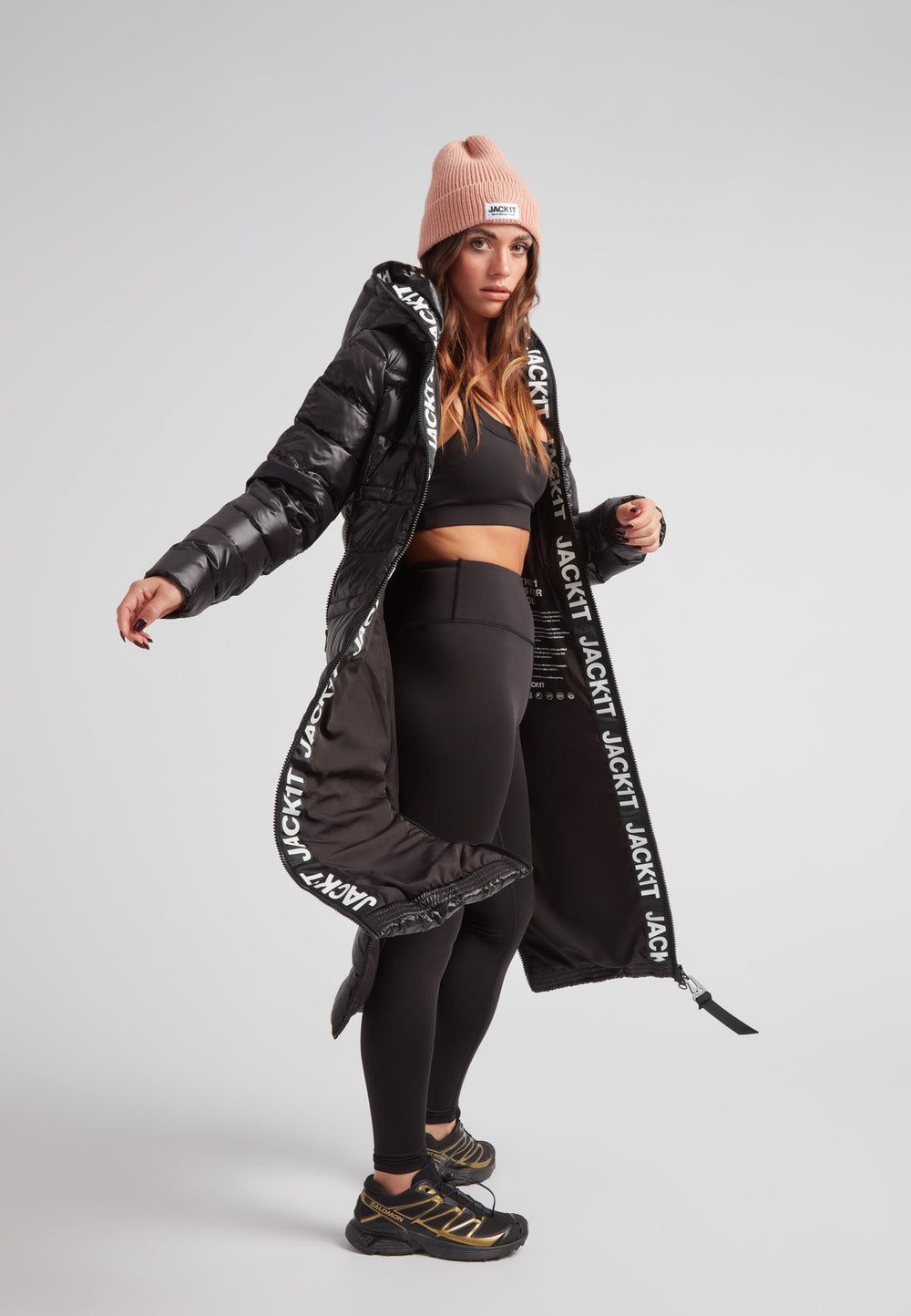 Model wearing the R4D Tramline Extra Long Down Coat Lux Black with stylish activewear.