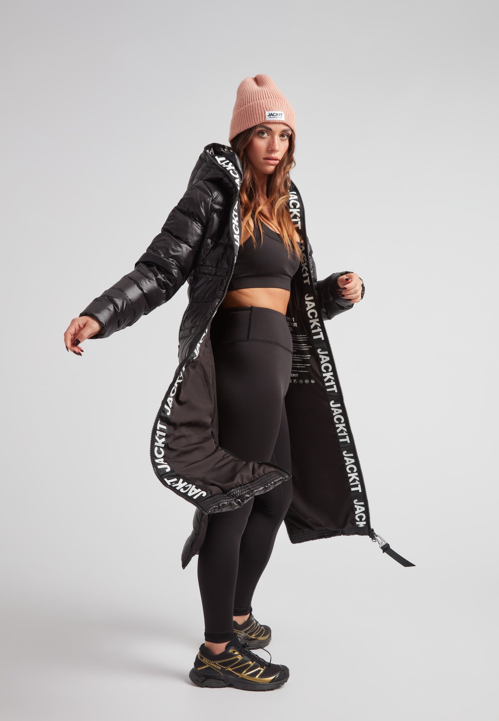 Model wearing the R4D Tramline Extra Long Down Coat Lux Black with stylish activewear.
