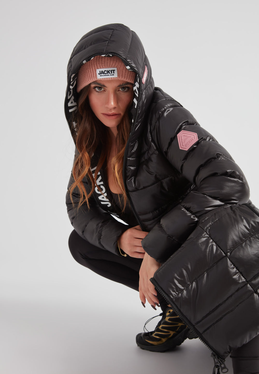 R4D Tramline Extra Long Down Coat Lux Black showcased on a model with a hood and stylish beanie, perfect for winter fashion.