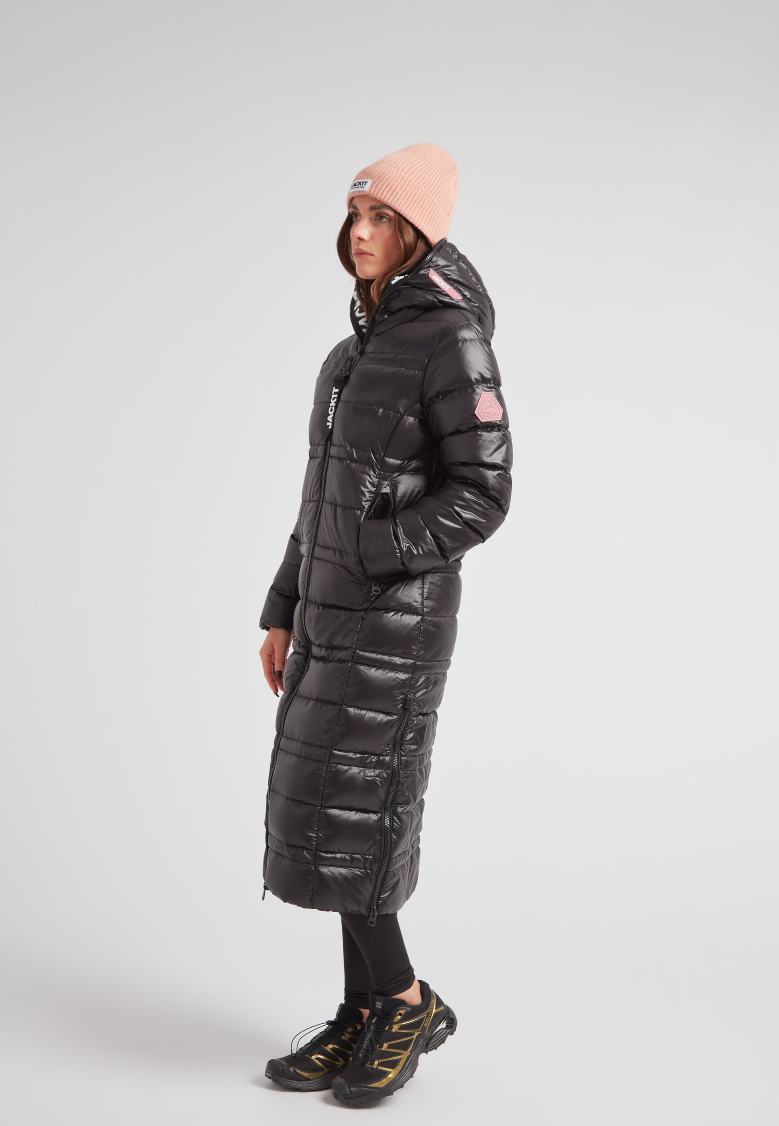 R4D Tramline Extra Long Down Coat Lux Black worn by a model, featuring a fixed hood and side-zip vents.