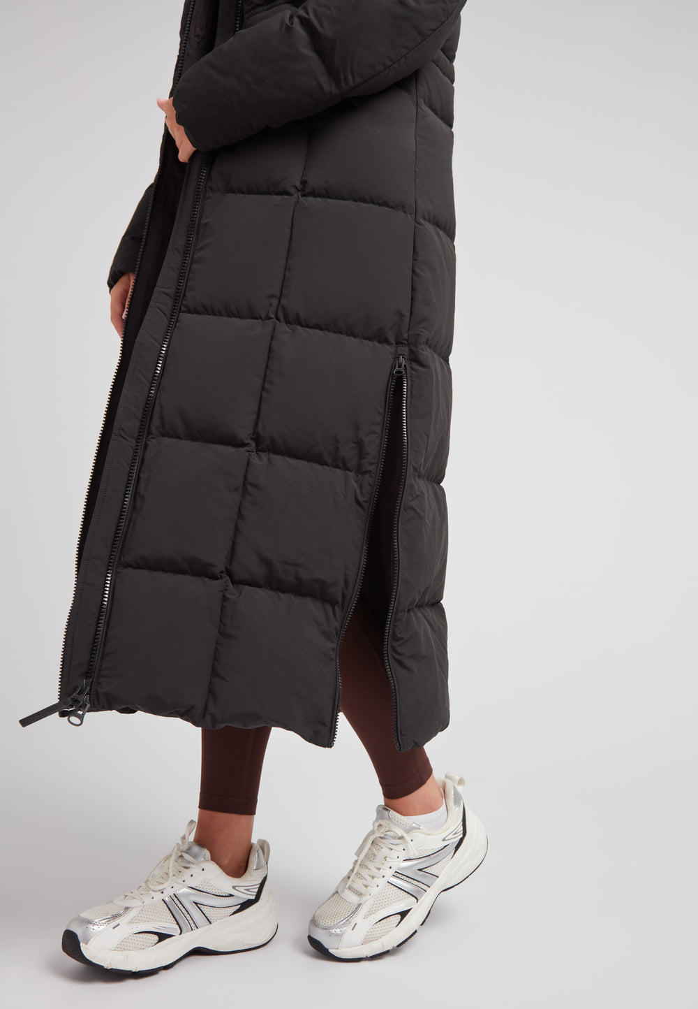 Black Star Extra Long Down Coat Matt Black showcased with sleek design and stylish silver sneakers.