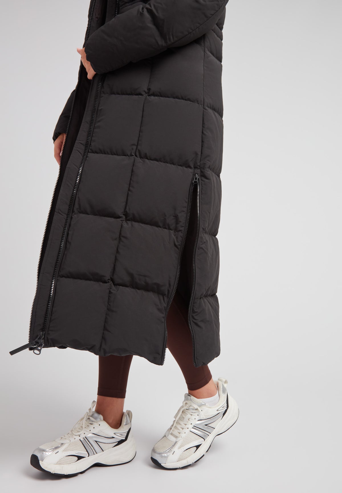 Black Star Extra Long Down Coat Matt Black showcased with sleek design and stylish silver sneakers.