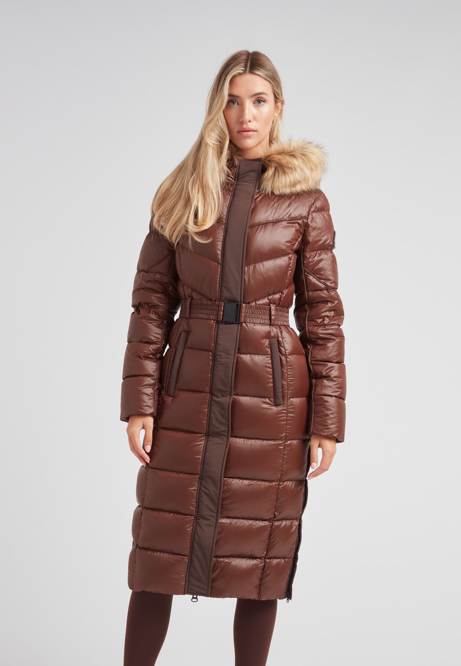 Women's puffer coat with fur hood in brown, featuring a belted waist and a sleek, insulated design.