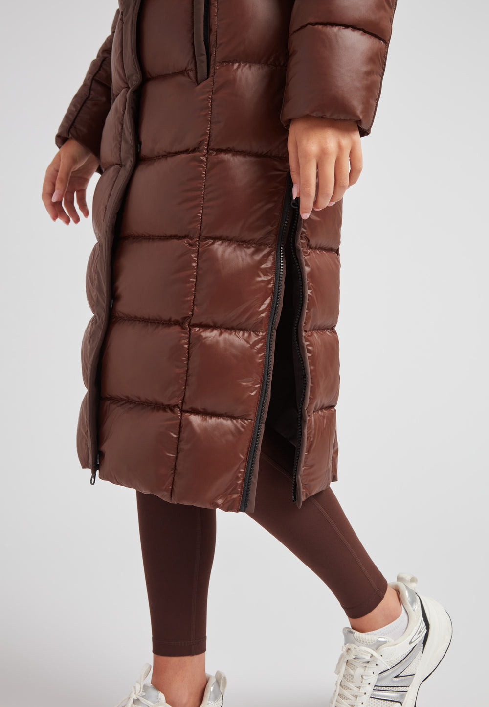 Women's puffer coat with fur hood in brown, featuring a stylish zip and quilted design.