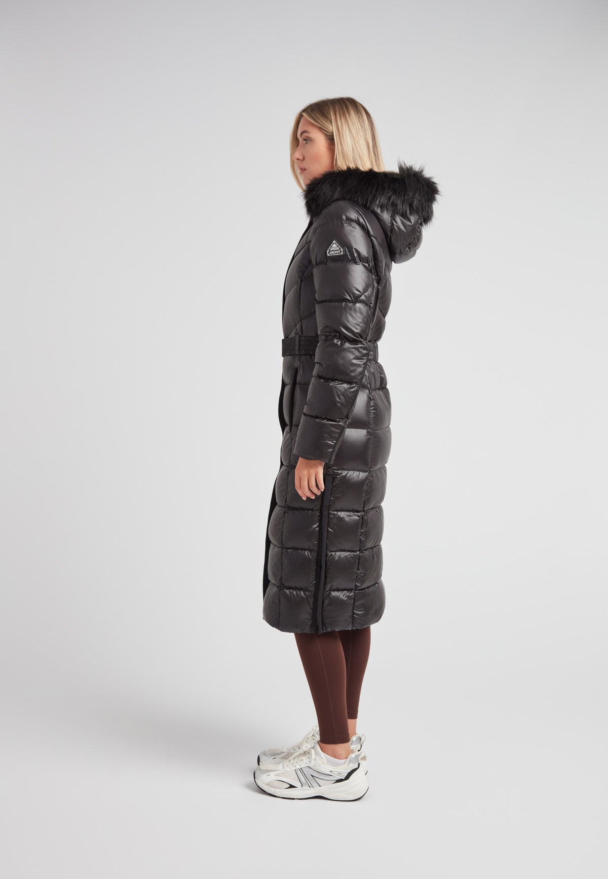 Women's puffer coat with fur hood in black featuring a stylish belted design and full-length silhouette.