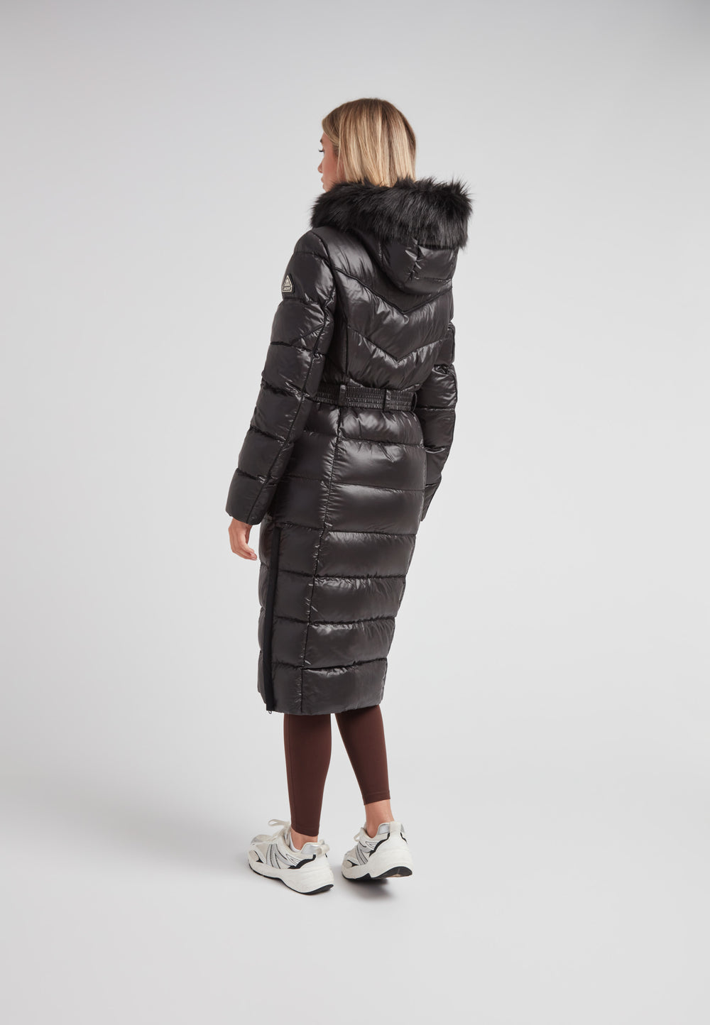 Women's puffer coat with fur hood in black, showcasing a sleek design and full-length silhouette.