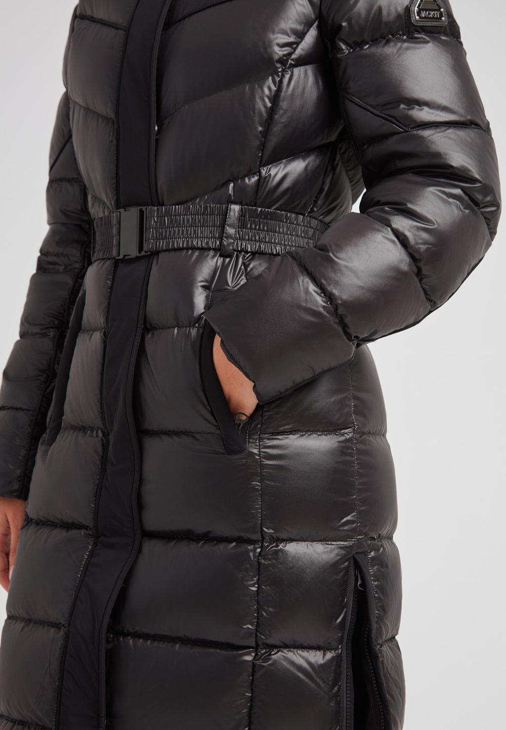 Women's puffer coat with fur hood in black featuring a belted waist and side pockets.