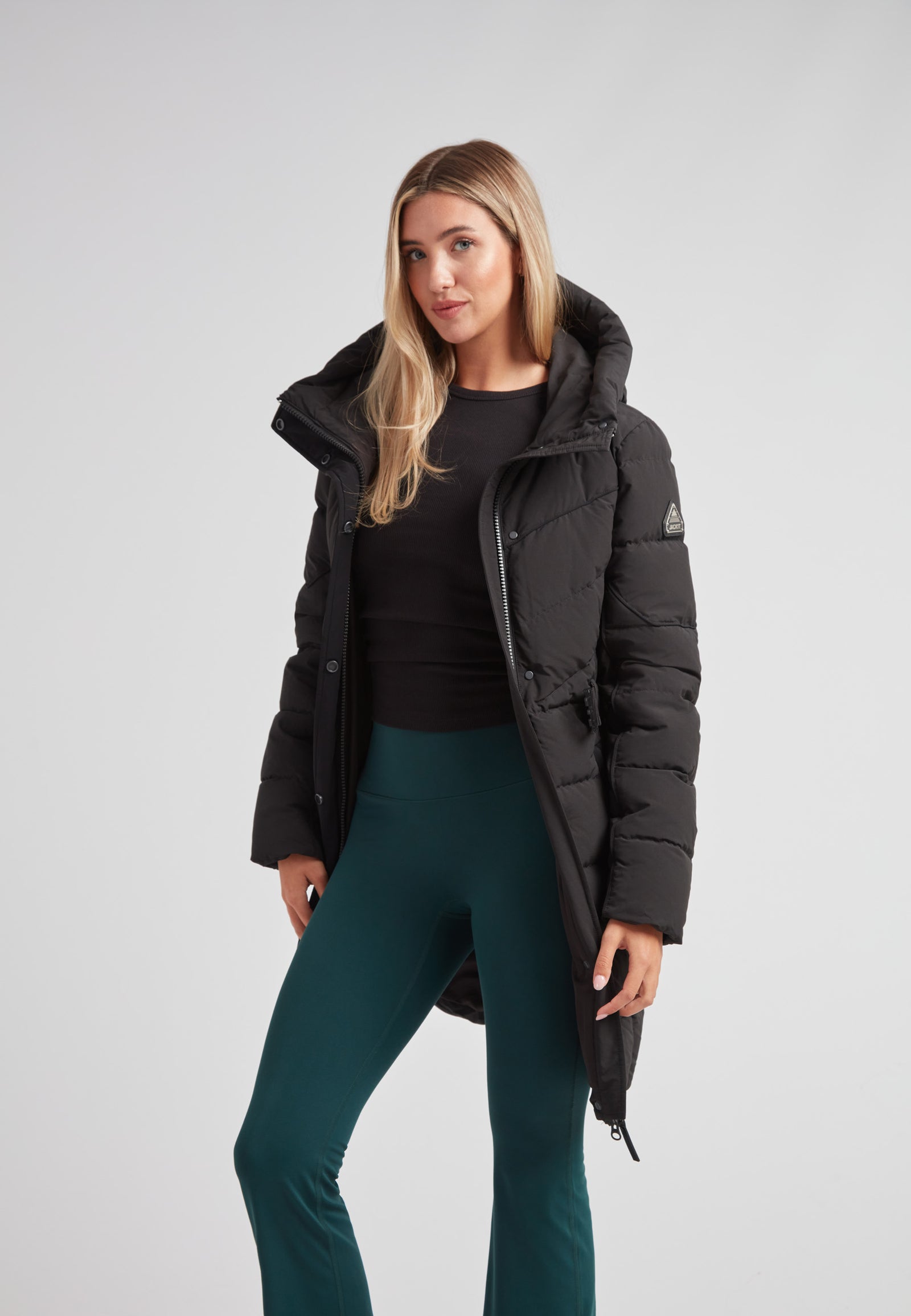 Woman wearing a stylish Diamond Belted Down Coat Matt Black with green pants.