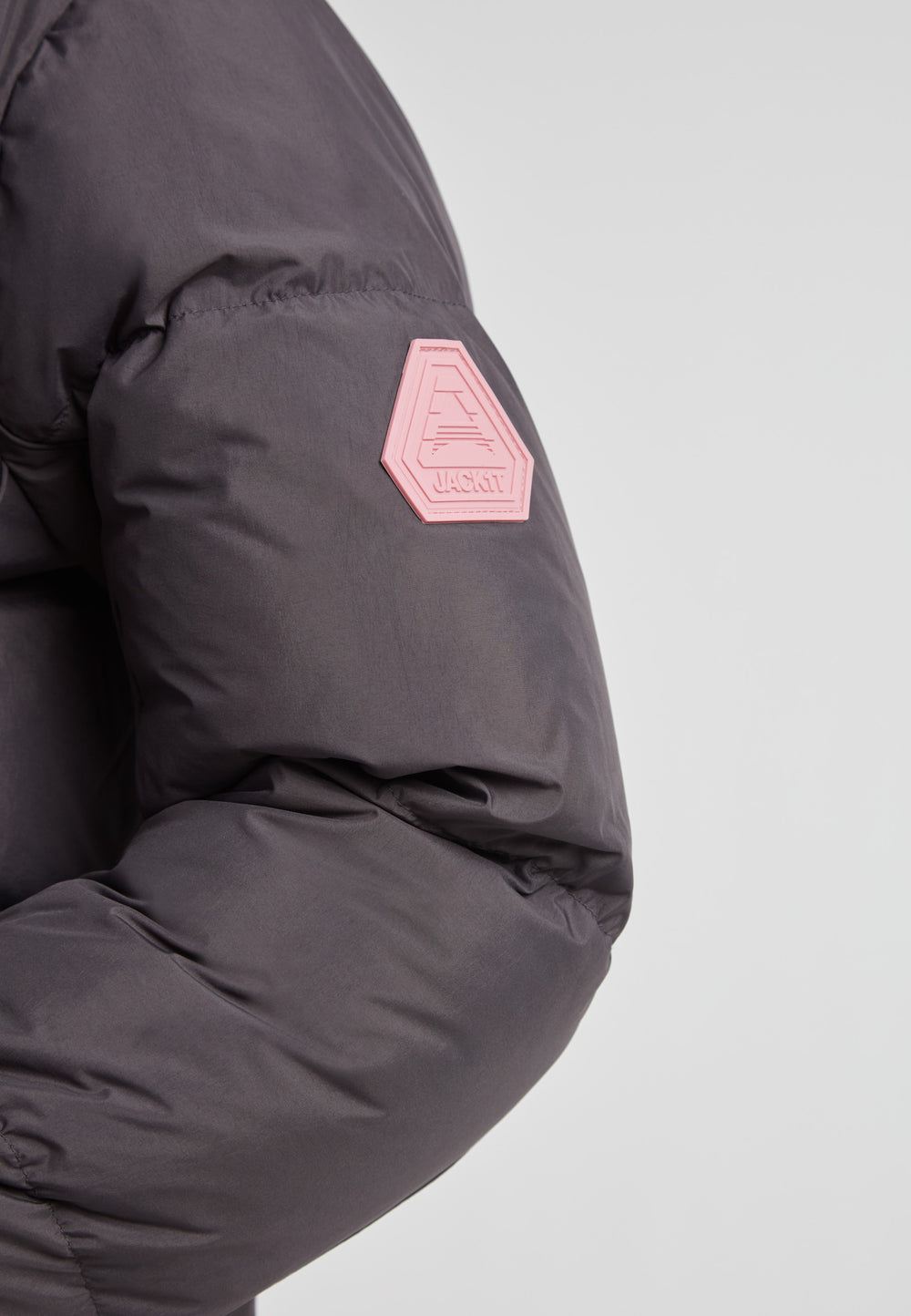 Close-up of the sleeve detail of the Star Shower Down Puffer Jacket Black with logo patch.