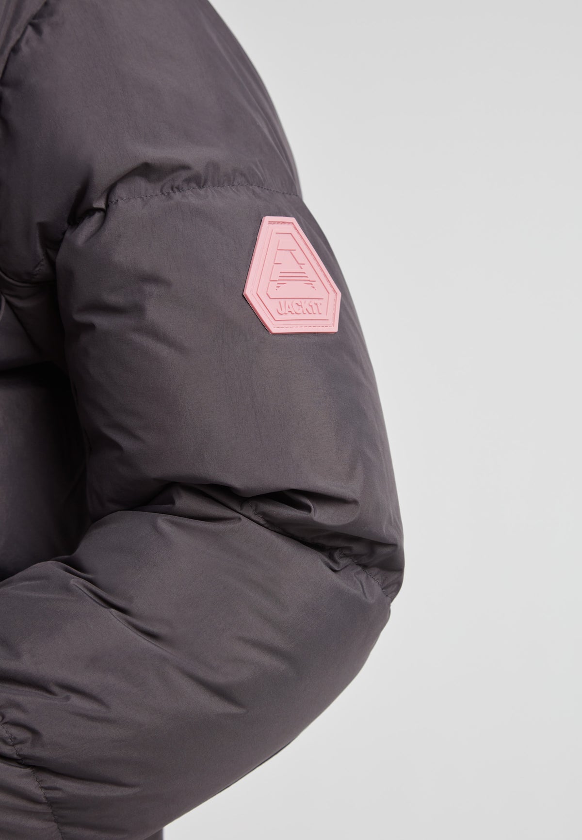 Close-up of the sleeve detail of the Star Shower Down Puffer Jacket Black with logo patch.