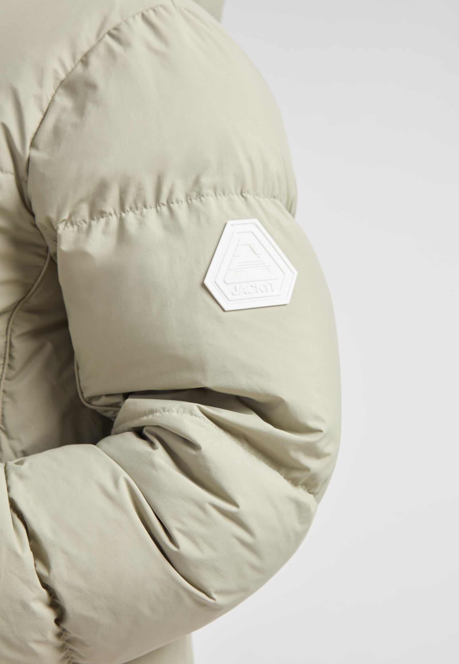 Close-up of the sleeve of the Star Shower Down Puffer Jacket Sage showcasing its stylish design and logo.