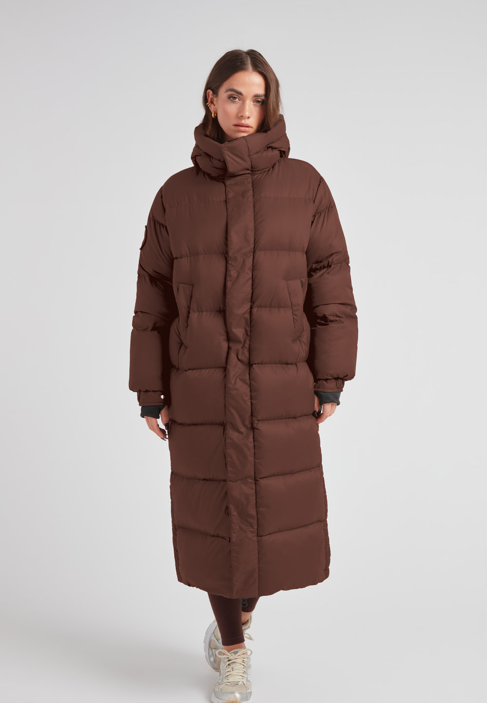 Cocoon Ultra Long Down Coat Mid Brown displayed on a model, featuring an oversized silhouette and a cozy hood.