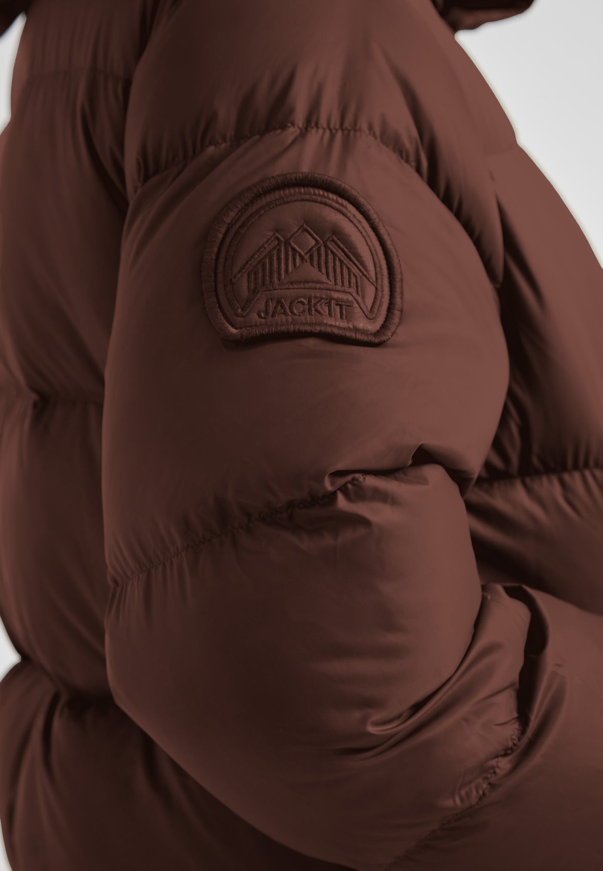 Cocoon Ultra Long Down Coat Mid Brown showcasing the textured sleeve and logo detail