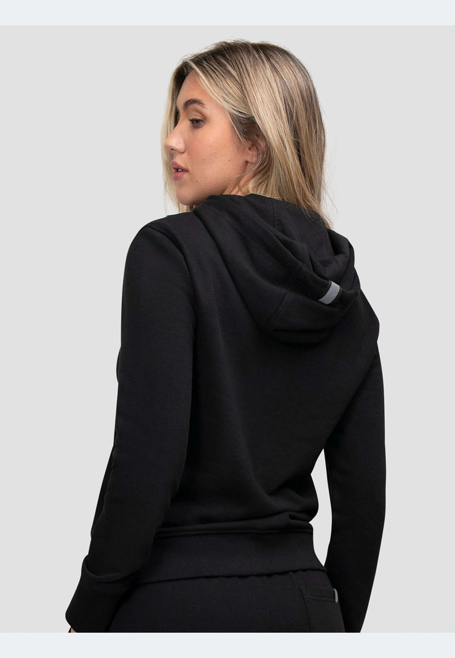 Woman wearing a zip through black hoodie from the back, showcasing its relaxed fit and premium fabric.