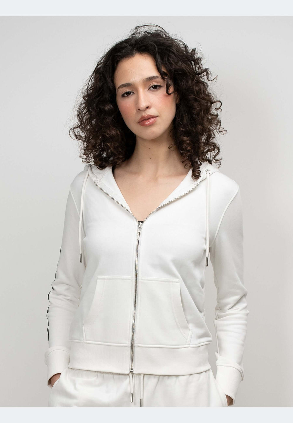 A model wearing an off white hoodie with a zip-through design, showcasing relaxed comfort and premium detailing.