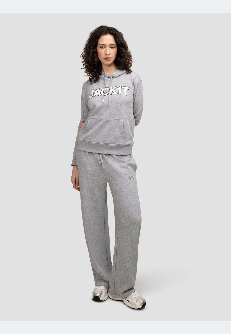 Stylish model wearing a grey hoodie with logo and matching pants in mid grey heather, showcasing relaxed comfort.