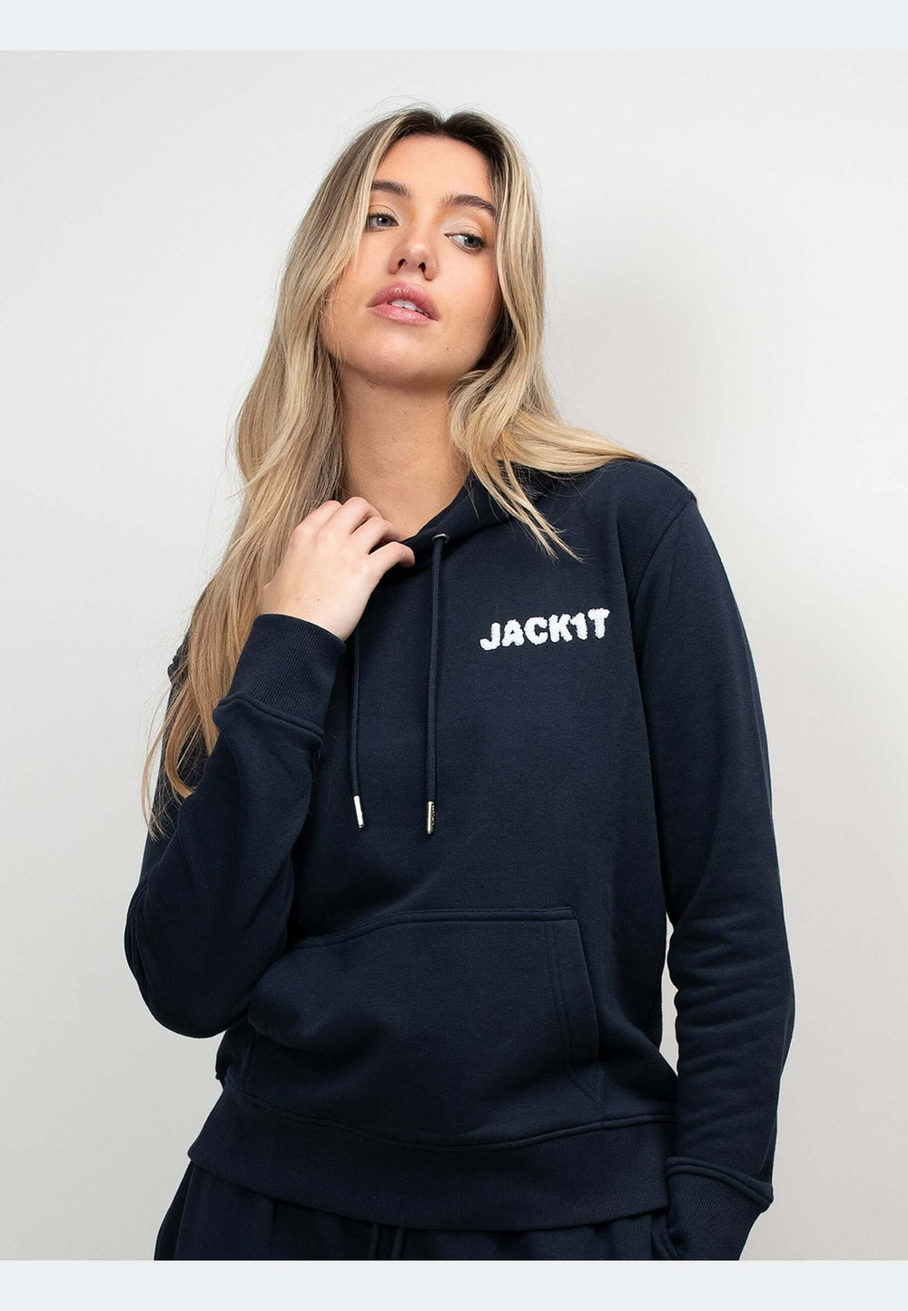 Woman wearing a navy hoodie with the logo JACKIT, highlighting comfort and style.