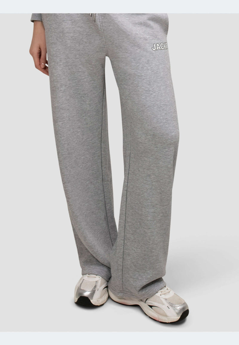 Wide-leg grey joggers with elastic waistband and side pockets, paired with stylish sneakers.