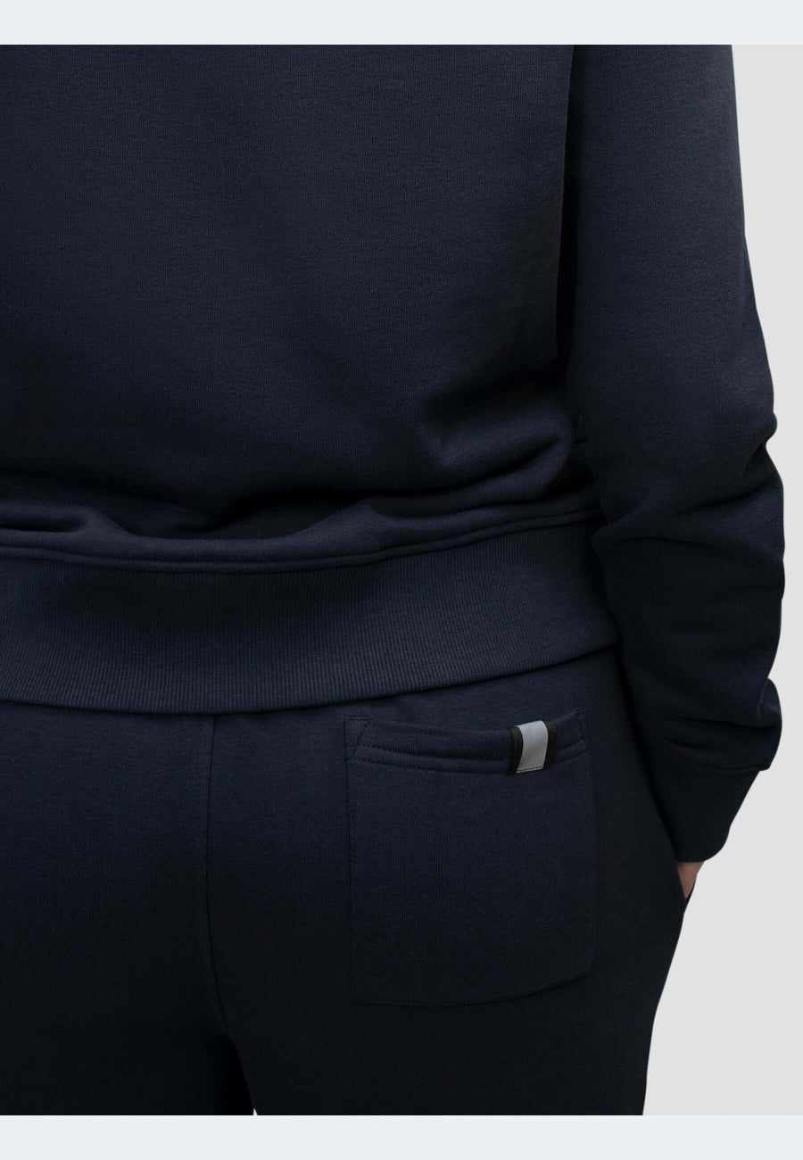 Close-up of navy joggers with elasticated waistband and back pocket detailing.