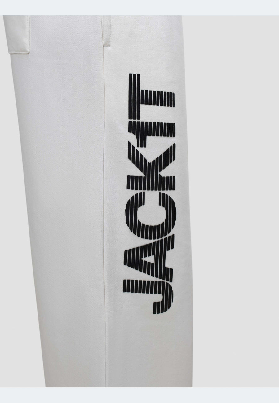 Close-up of off white joggers with black 'JACKIT' branding on the side for a stylish touch.