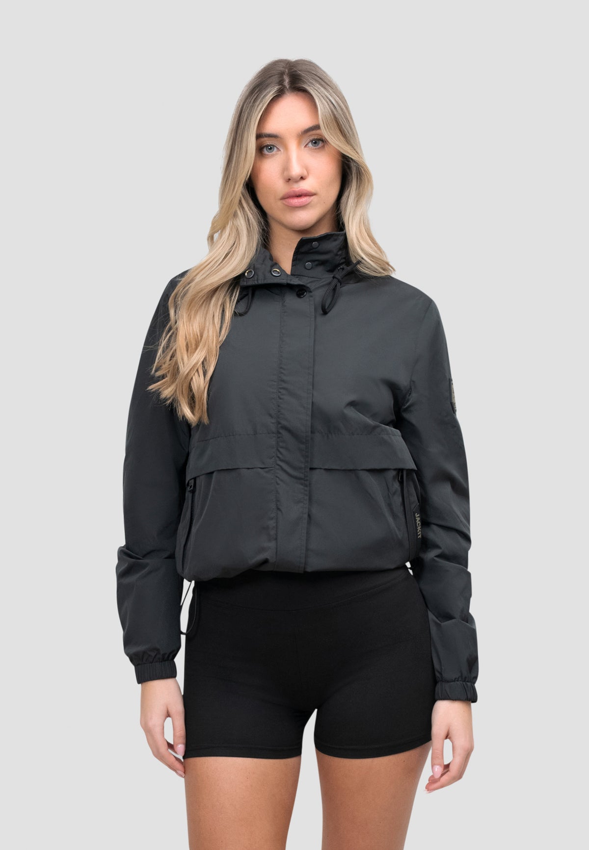 Model wearing a Women's Black Windbreaker with stow-away hood and breathable mesh lining.