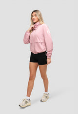 Model wearing a women's pink windbreaker paired with black shorts, showcasing a lightweight and stylish spring outfit.