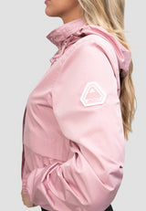 Side view of a woman wearing a lightweight women's pink windbreaker with a stow-away hood.