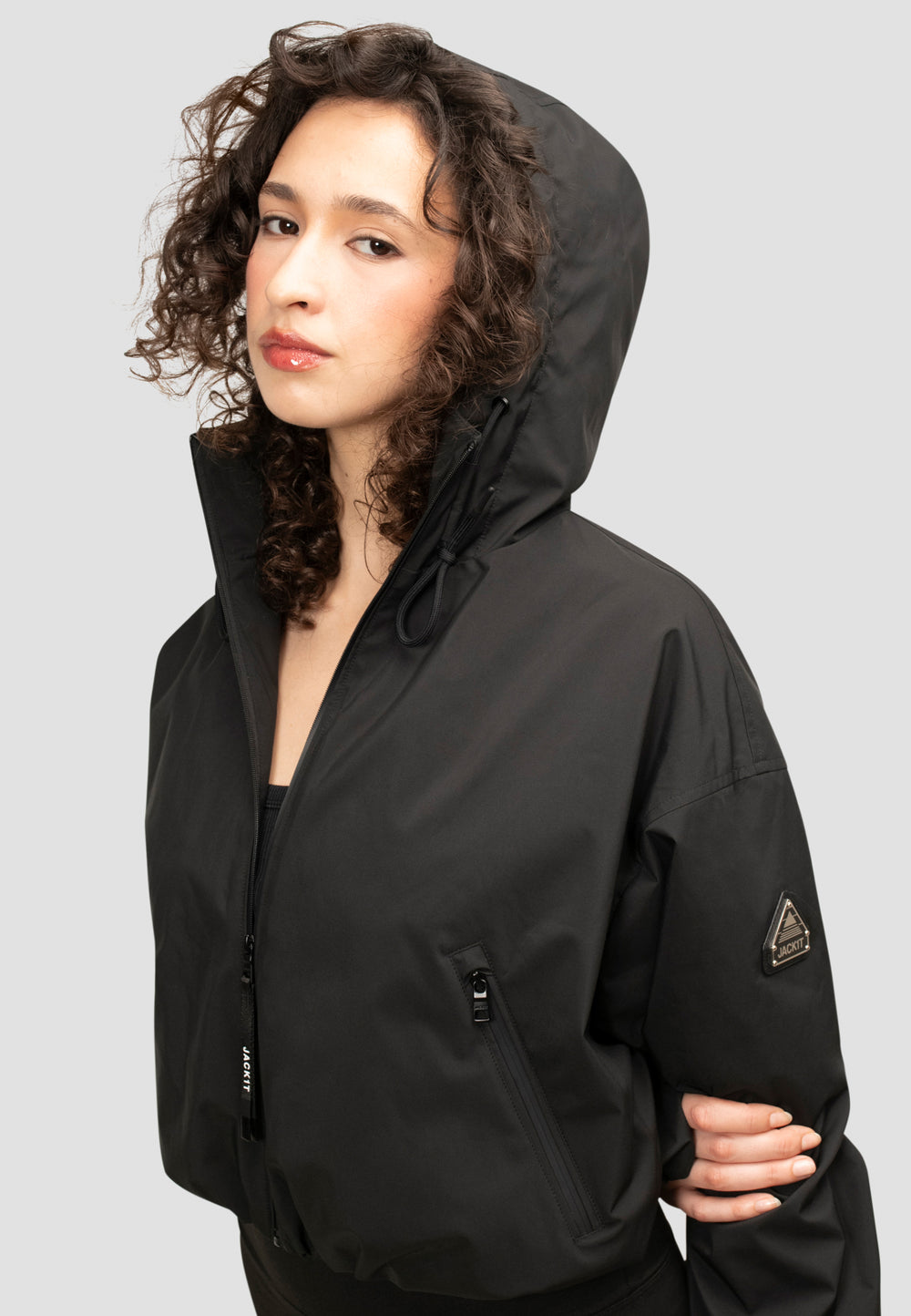women's black cropped jacket model wearing a hooded windbreaker with relaxed fit and cropped silhouette