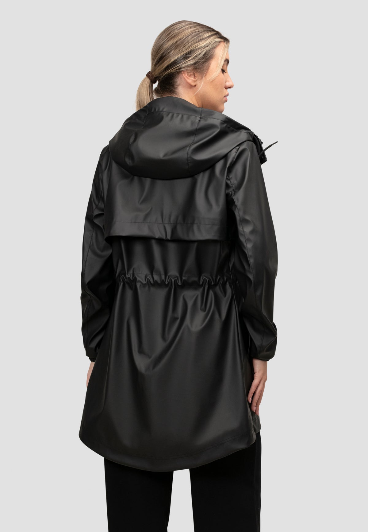Back view of a women's black raincoat with cape design, featuring a lightweight and water-resistant material.